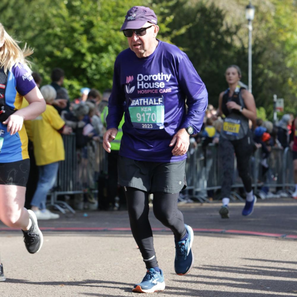 Man running for Dorothy House in Bath Half Marathon wearing purple top and cap